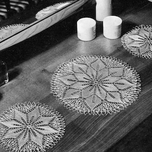 May include: Three white crocheted doilies on a wooden surface. The doilies are circular and have a delicate lace pattern.