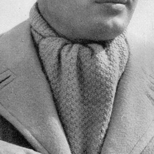 May include: A black and white photo of a man wearing a gray jacket and a knitted scarf. He is looking to the right of the frame.