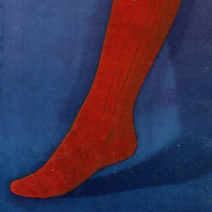 Puede incluir: Un calcetín de punto rojo con textura acanalada. El calcetín está sobre un fondo azul.