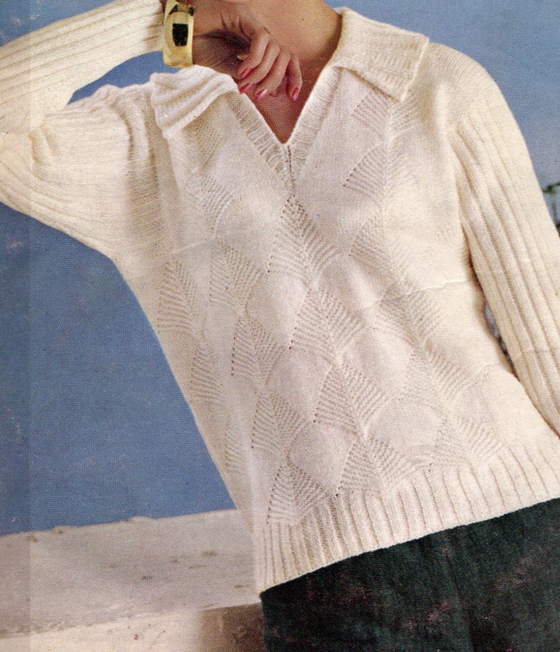 Puede incluir: Su&eacute;ter color crema con cuello en V y patr&oacute;n texturizado en forma de diamante. El tejido de punto de manga larga tiene pu&ntilde;os y dobladillo acanalados. La modelo lleva una pulsera dorada.