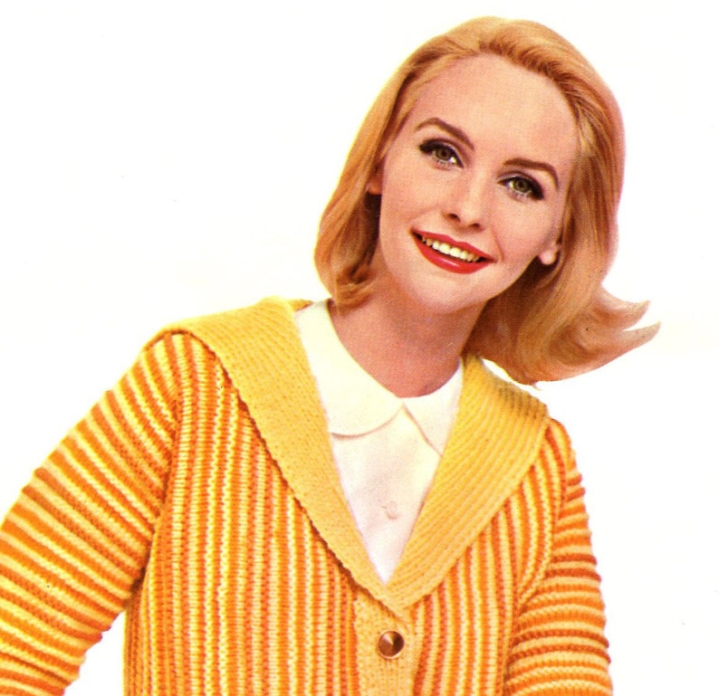 May include: A woman with blonde hair is wearing a yellow and orange striped cardigan with a white collared shirt underneath. The cardigan has a wide collar and a single button closure.