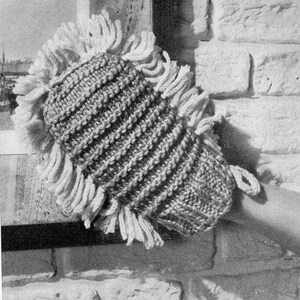 May include: A knitted gray dishcloth with a white fringe around the edges. The dishcloth is made with a textured stitch pattern.