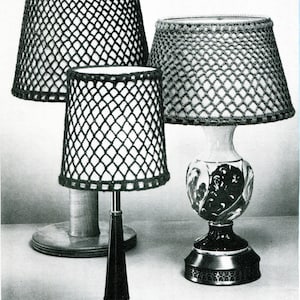 May include: Three crocheted lampshades in a black and white pattern. The lampshades are made of a fine mesh material and are in various sizes. The lampshades are on three different lamp bases.
