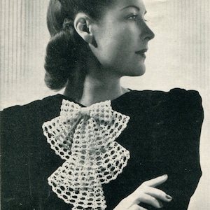 May include: A black and white photo of a woman wearing a black dress with a white crocheted collar. The collar has a bow in the front and is layered.
