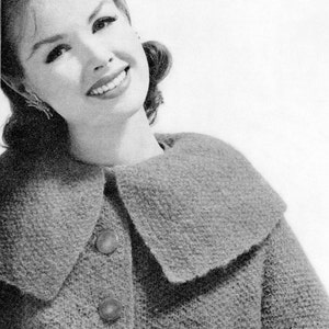 May include: A woman wearing a knitted cardigan with a large, wide collar and button closures. The cardigan is a light gray color and has a textured knit pattern.