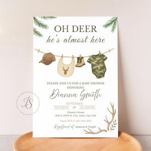 Może przedstawiać: Zaproszenie na baby shower z napisem "OH DEER he's almost here". Zaproszenie zawiera brązową czapkę bejsbolową, śliniaczek, buty i kombinezon moro wiszące na sznurku. Zaproszenie jest dla Dianny Smith.