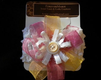White crocheted headband with multicolored button bow