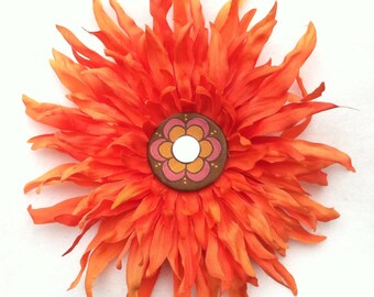 Orange sunburst flower with decorative button center