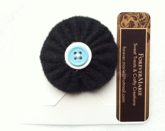 Black felt yo yo with white and blue button center