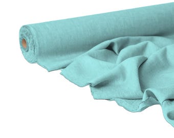 May include: A roll of light teal fabric with a soft, textured appearance. The fabric is partially unrolled, revealing its draped folds. The material appears to be lightweight and suitable for various sewing projects.