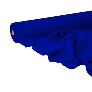 Op de afbeelding: Een rol helderblauwe stof, gedeeltelijk afgerold om de zachte textuur te laten zien. De stof is een diep, verzadigd blauw, met zichtbare plooien en draperingen. De kern van de rol is lichtbruin.