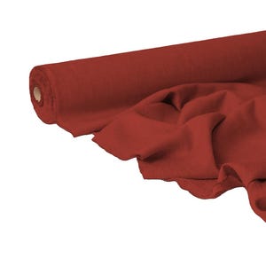Puede incluir: Un rollo de tela roja oscura con una sección desenrollada, mostrando pliegues suaves. La tela es de color rojo liso y el rollo está situado en el lado izquierdo de la imagen.