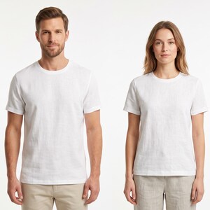 May include: Two plain white short-sleeved t-shirts with a crew neckline. The shirts are made of a solid white fabric and feature a standard fit with straight hems, providing a clean and simple appearance for everyday clothing options.