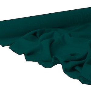 May include: A roll of teal fabric, partially unrolled to reveal the soft texture. The fabric is a solid, deep teal color, with visible folds and drapes. The roll's core is a light brown color.