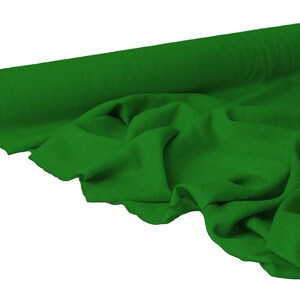 May include: A roll of vibrant green fabric, partially unrolled to reveal the soft texture. The fabric is a solid, rich green color, with visible folds and drapes, suggesting a flowing material suitable for various sewing projects.