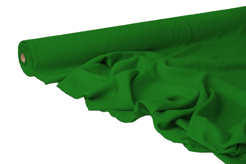 May include: A roll of vibrant green fabric, partially unrolled to reveal the soft texture. The fabric is a solid, rich green color, with visible folds and drapes, suggesting a flowing material suitable for various sewing projects.