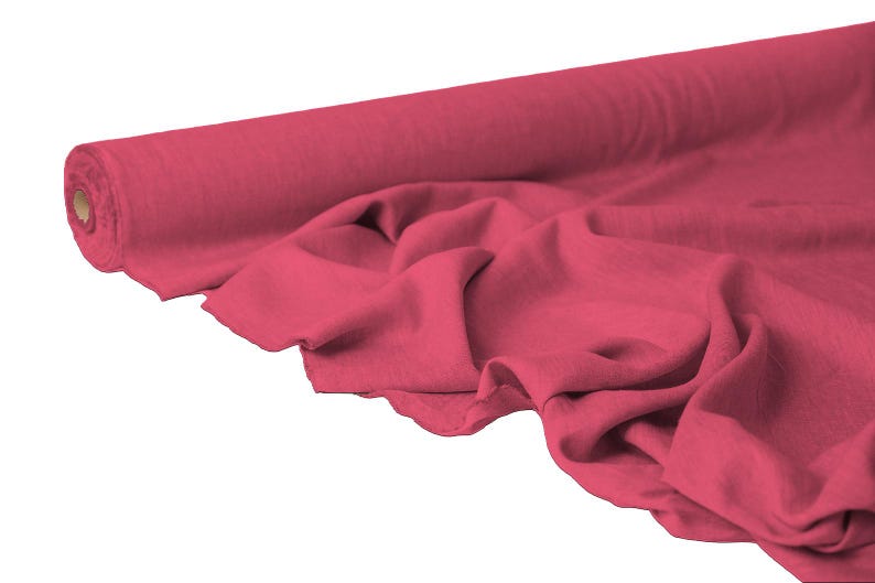 May include: A roll of vibrant red fabric, partially unrolled to reveal the texture. The fabric is a solid color and appears soft, with visible folds and creases. The background is plain white.