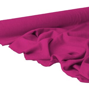 May include: A roll of vibrant fuchsia fabric, partially unrolled to reveal soft folds. The fabric is a solid color, with a smooth texture. Ideal for sewing projects, the fabric is a bold statement.