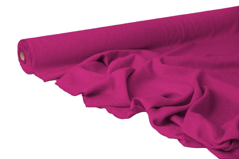 May include: A roll of vibrant fuchsia fabric, partially unrolled to reveal soft folds. The fabric is a solid color, with a smooth texture. Ideal for sewing projects, the fabric is a bold statement.