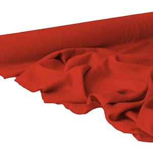 May include: A roll of vibrant red fabric, partially unrolled to reveal the texture and drape of the material. The fabric is a solid color, with soft folds and a visible core of the roll.