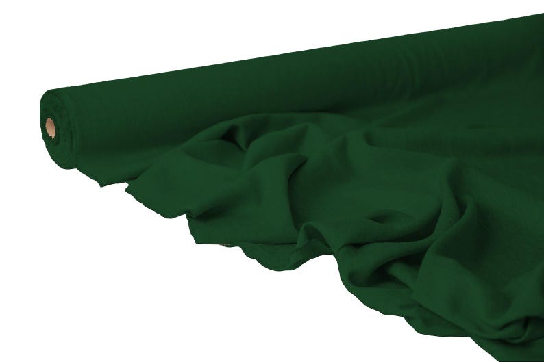 May include: A roll of dark green fabric with a smooth texture. The fabric is partially unrolled, revealing soft folds and draping. The color is a deep, rich shade of green.