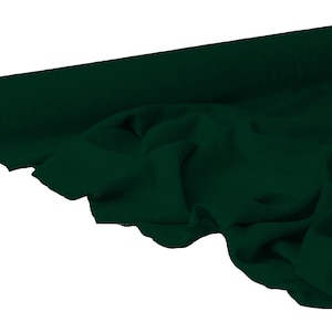 May include: A roll of dark green fabric, partially unrolled to reveal the draped material. The fabric is a solid, deep shade of green, with visible texture and folds. The roll's core is visible on the left side.