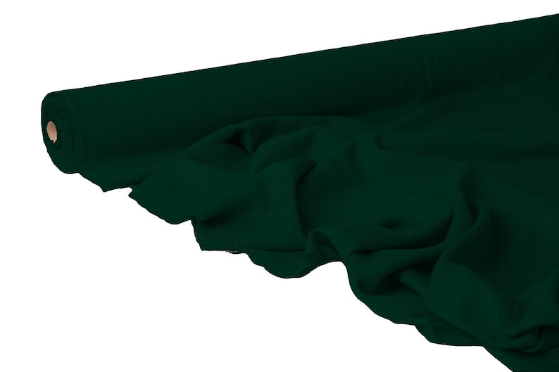 May include: A roll of dark green fabric, partially unrolled to reveal the draped material. The fabric is a solid, deep shade of green, with visible texture and folds. The roll's core is visible on the left side.