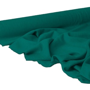 May include: A roll of teal fabric, partially unrolled to reveal the soft texture. The fabric is a solid teal color, with visible folds and drapes. The roll is positioned on the left side of the image, with the unrolled fabric cascading towards the right.
