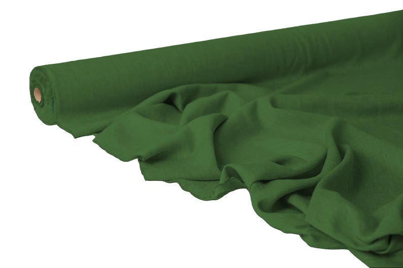 May include: A roll of dark green fabric, partially unrolled to reveal the draped material. The fabric has a soft, flowing appearance, with visible folds and creases. The roll is cylindrical, with a cardboard core. The color is a deep, forest green.