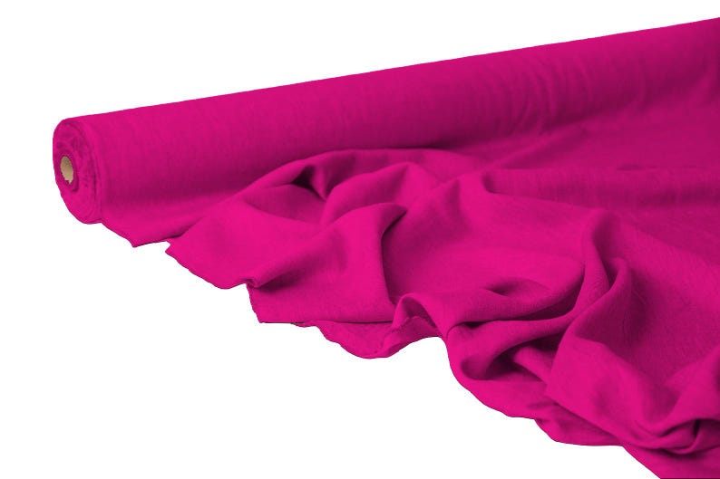May include: A roll of vibrant fuchsia fabric, partially unrolled to reveal soft folds. The fabric is a solid color, with a smooth texture. Ideal for sewing, crafting, or other textile projects.