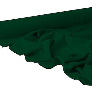 May include: A roll of dark green fabric, partially unrolled to reveal the draped material. The fabric is a solid, deep shade of green, with visible folds and textures. The roll's core is a light brown color.
