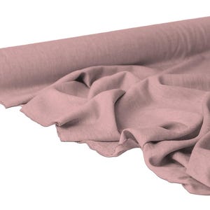 May include: A roll of dusty rose-colored fabric, partially unrolled to reveal soft folds. The fabric appears to be linen or a similar lightweight material, ideal for clothing or home decor projects. The roll is positioned on a white background.