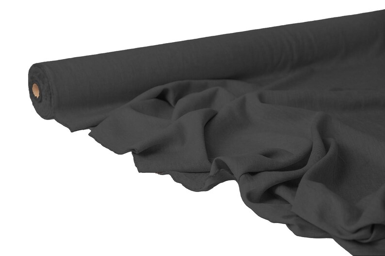May include: A roll of dark gray fabric, partially unrolled to reveal the draped material. The fabric appears soft and has a matte finish. The roll is cylindrical with a cardboard core. Ideal for sewing and crafting projects.