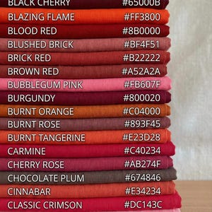 May include: A stack of fabric swatches in various shades of red, pink, and orange. Each swatch is labeled with a color name and a corresponding hexadecimal color code. Colors include Bitter Chocolate, Black Cherry, and Blazing Flame.