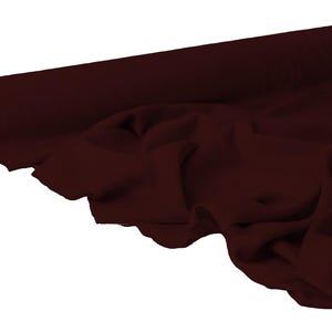 May include: A roll of burgundy fabric, partially unrolled to reveal the texture and drape of the material. The fabric is a deep, rich shade of red-brown, with soft folds and a smooth appearance. The roll is positioned on a white background.