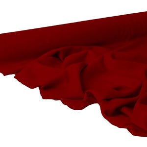 May include: A roll of deep red fabric, partially unrolled to reveal soft folds. The fabric is a solid color, with a smooth texture. The roll is positioned at an angle, with the unrolled portion cascading down.