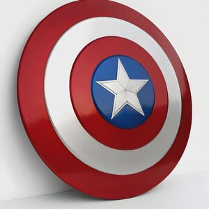 May include: A red, white, and blue shield with a star in the center. The shield has a circular design with a red outer ring, a white middle ring, and a blue center with a white star. The shield is a prop or collectible.
