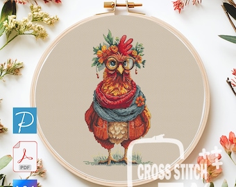Puede incluir: Un patrón de punto de cruz con una gallina caprichosa con gafas, una corona de flores y una bufanda. El diseño está en un bastidor de bordado de madera. El texto "CROSS STITCH JALS" es visible. La paleta de colores incluye tonos de rojo, naranja, azul y verde.