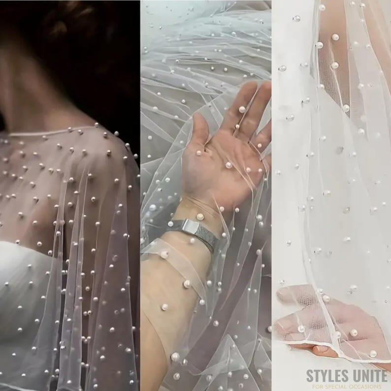May include: A sheer white fabric adorned with scattered, round, pearl-like embellishments. The fabric is draped, suggesting its use in bridal or formal wear. The image showcases the texture and detail of the fabric, highlighting its delicate nature.