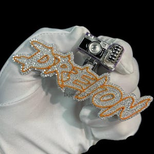 Pingente personalizado com nome hip hop e borda laranja Meena "DREION" com câmera no topo em prata esterlina 925 e moissanita VVS para homens