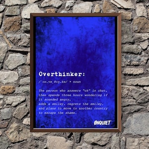 May include: A framed print with a deep blue background and the word "Overthinker" in white. The definition describes someone who overanalyzes their online interactions. The print includes the brand name "ØNQUIET".