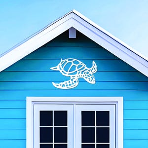May include: A white, laser-cut sea turtle wall art decoration is mounted on a blue wall above a white-framed double door. The turtle has a detailed shell design and is positioned as if swimming.