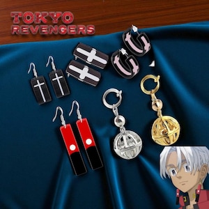 May include: A collection of earrings and keychains with a Tokyo Revengers theme. The earrings include black rectangles with white crosses, red and black rectangles with white dots, and black hoops with pink accents. The keychains feature silver and gold spherical designs.