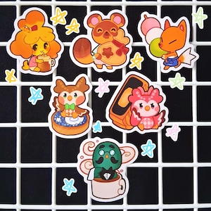 Puede incluir: Una colección de pegatinas de dibujos animados coloridos con personajes de un videojuego popular. Las pegatinas incluyen varios personajes de animales, como un zorro, un búho y un mapache, junto con acentos en forma de estrella.