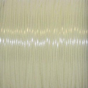 May include: A spool of clear, flexible monofilament cord wound tightly in multiple parallel layers. The material is translucent, smooth, and cylindrical, reflecting light along its length to create a series of vertical highlights across the surface.