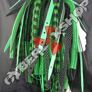 May include: Green and black synthetic dreadlocks with a green and black checkered pattern. The dreadlocks are tied together with black elastic bands.