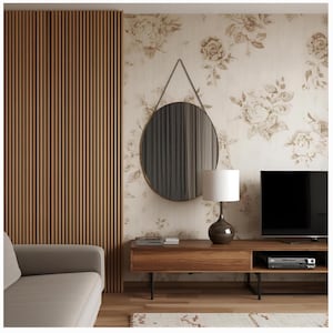 May include: A modern living room featuring a round mirror with a thin gold frame hanging on a floral wallpapered wall. A wooden console with a lamp and TV sits below the mirror. A wooden slatted wall and a beige sofa are on the left.
