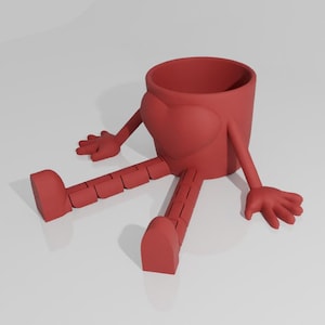 Puede incluir: Una maceta roja con un diseño en forma de corazón en la parte delantera. La maceta tiene brazos y piernas segmentadas, lo que le da una apariencia caprichosa y de dibujos animados. La maceta está sobre una superficie blanca.