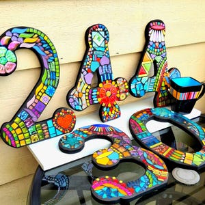 a collection of colorful mosaic letters and shapes, including the numbers '24', '30', and '60', as well as a mosaic-style cup.