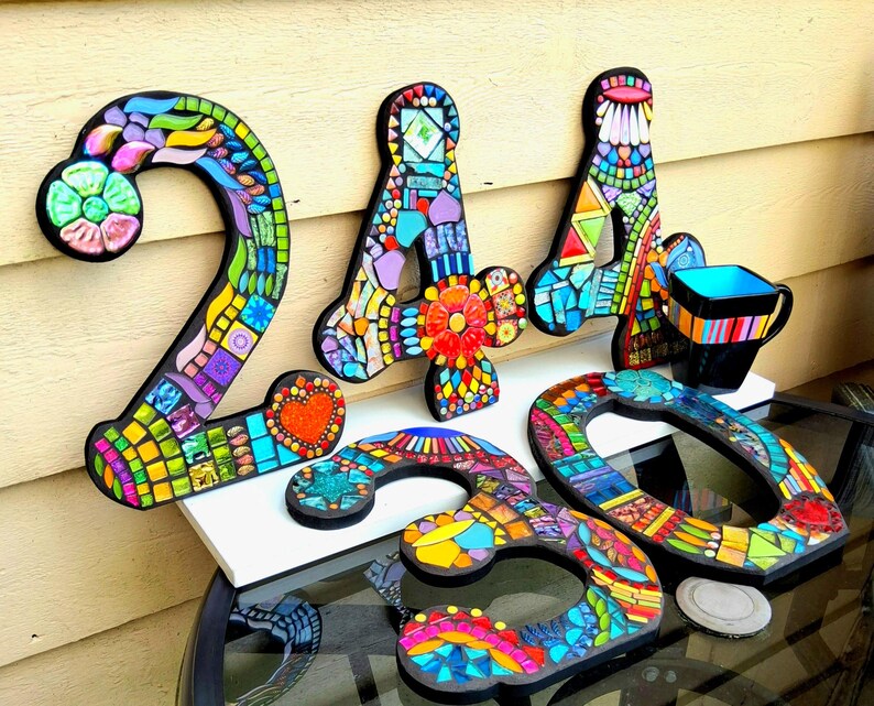 a collection of colorful mosaic letters and shapes, including the numbers '24', '30', and '60', as well as a mosaic-style cup.